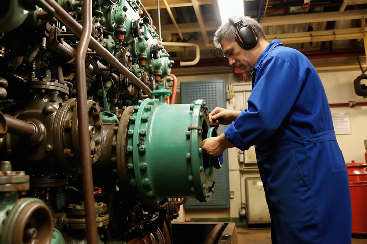 A maintenance engineer working on the bearing area of large rotating industrial machinery